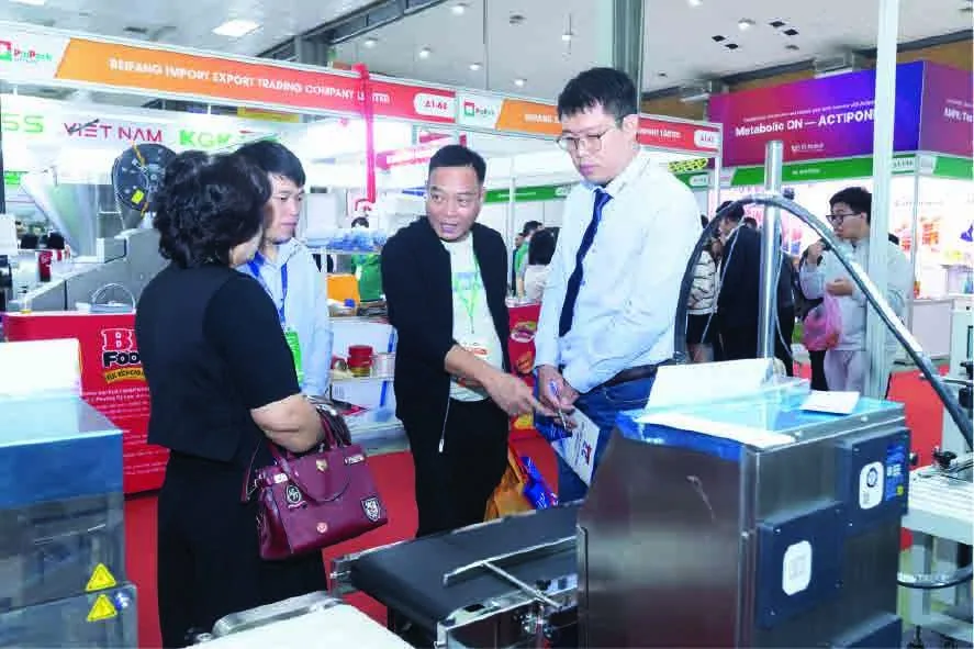 Visitors watching a food processing machine demonstration at ProPack Vietnam Hanoi 2025